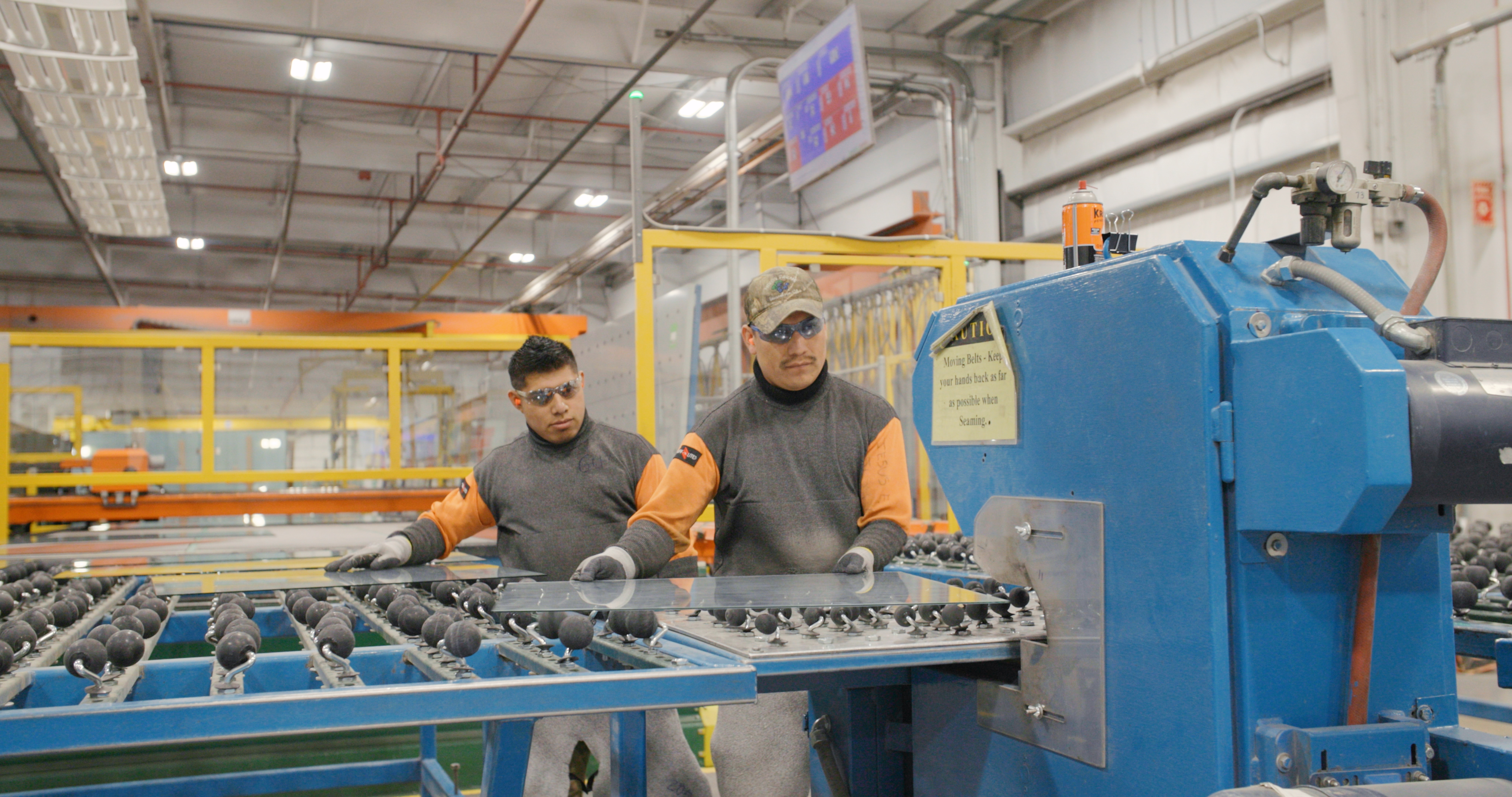 Cardinal SGCG employees handling glass on a conveyor belt