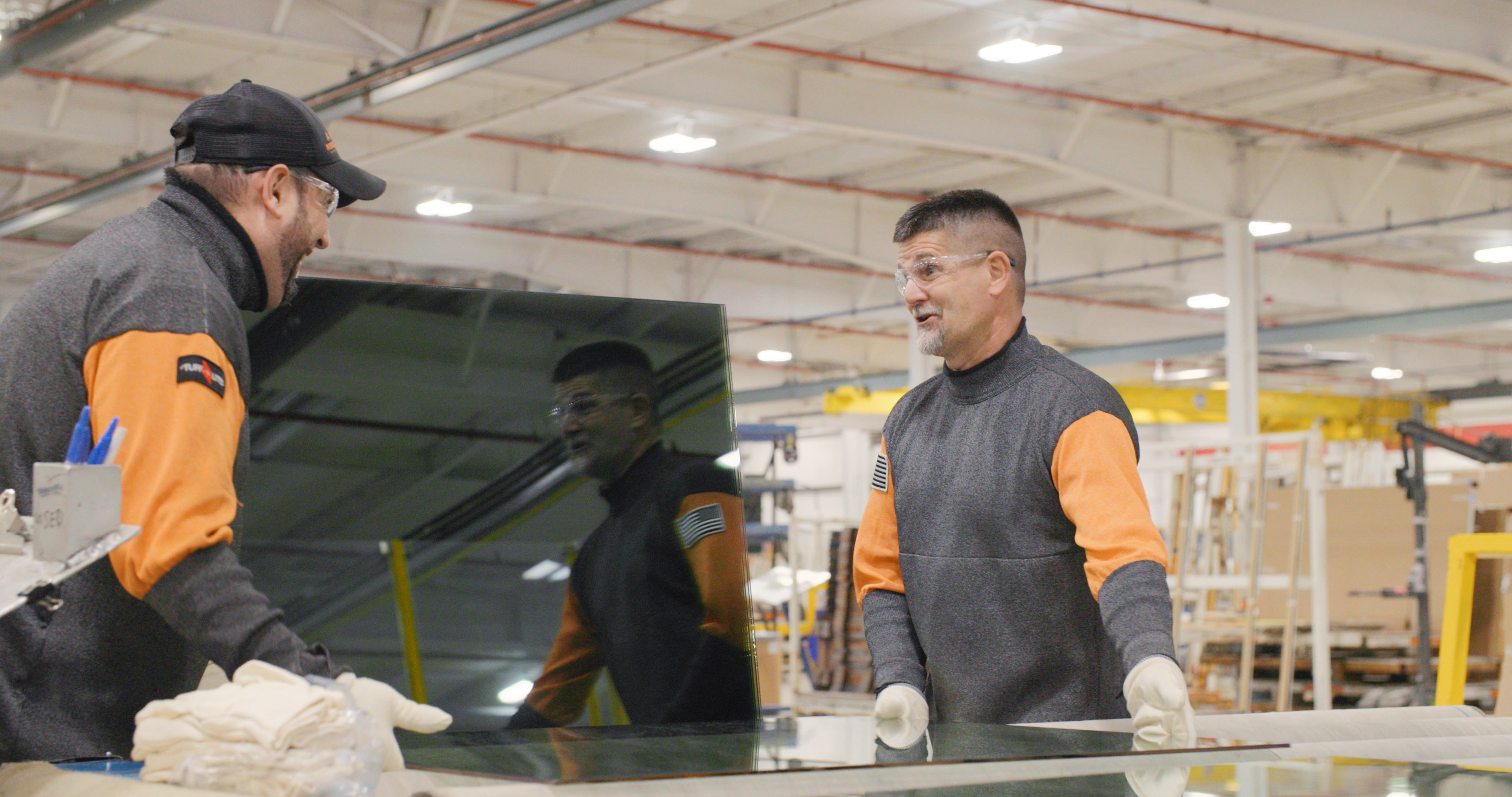 Two Cardinal Employees moving glass together