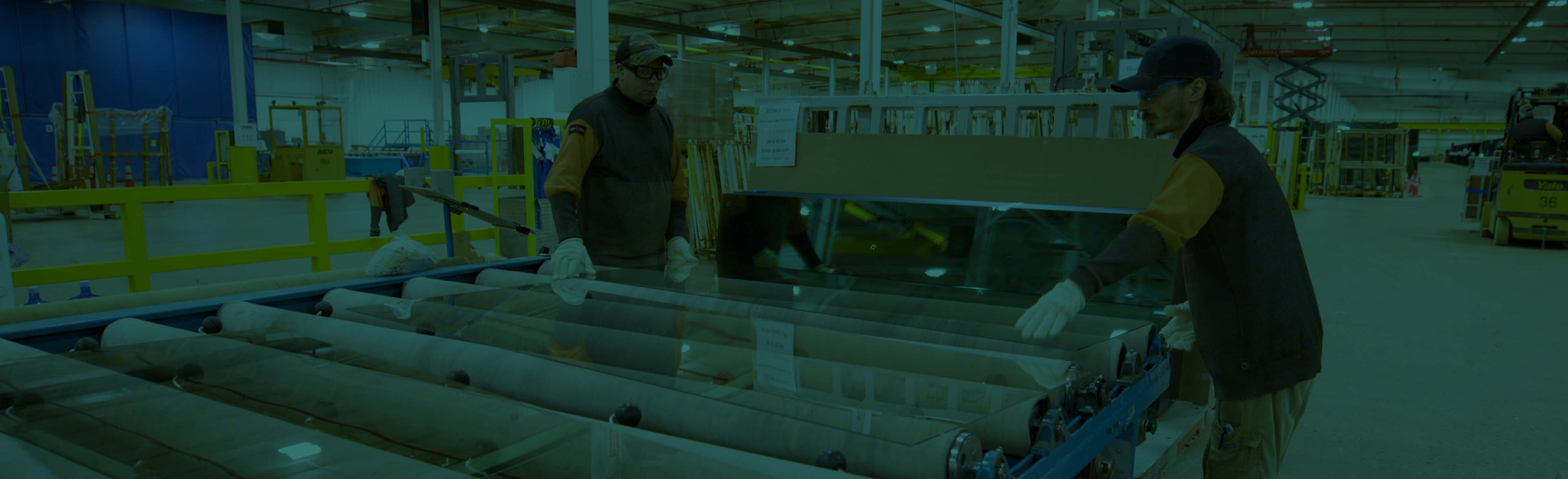 A pair of Cardinal workers handle glass in teh Cardinal factory.